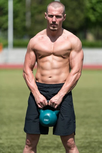 ケトルベル屋外で働く男性 ケトルベルで体重運動をするボディビルダー — ストック写真