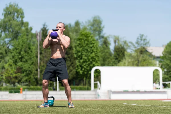 Mężczyzna Ćwiczy Kettle Bell Zewnątrz Kulturysta Robi Ciężkie Ćwiczenia Kettle — Zdjęcie stockowe