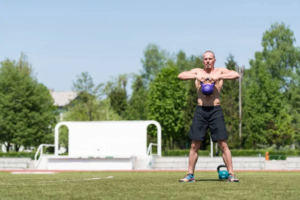 Man Exercising Kettle Bell Outdoor Flexing Muscles Muscular Athletic Bodybuilder — Stock Photo, Image