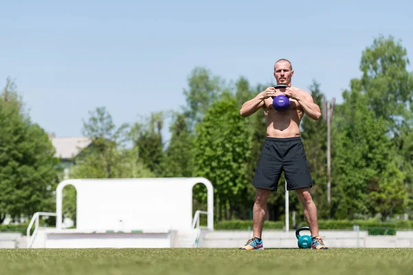 Man Exercising Kettle Bell Outdoor Flexing Muscles Muscular Athletic Bodybuilder — Stock Photo, Image