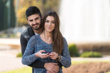 Park 'taki Mobil Akıllı Telefonları Bekleyen Genç Çift