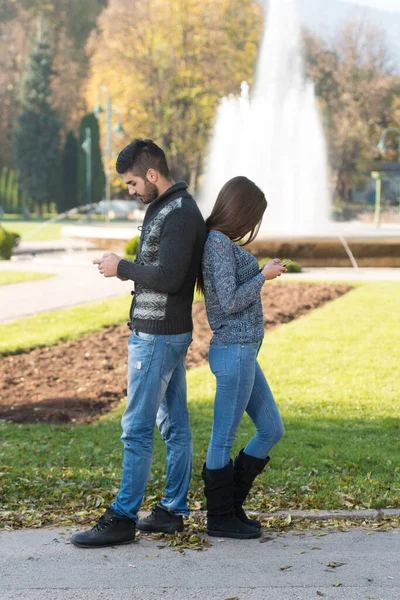 Joven Pareja Sosteniendo Mirando Teléfono Inteligente Móvil Aire Libre Parque —  Fotos de Stock