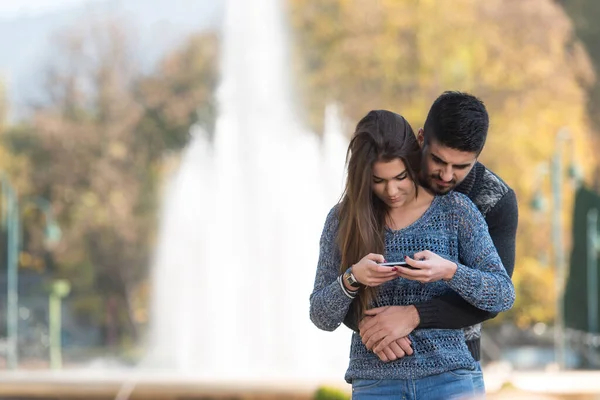 Young Couple Standing Beautiful Autumn Day Typing Phone Park — ストック写真