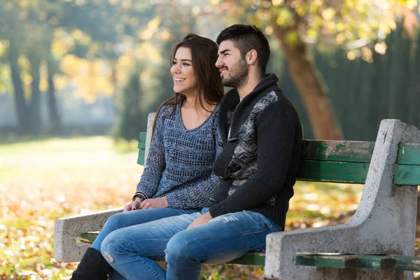 年轻夫妇坐在长椅上 在美丽的秋天天 — 图库照片