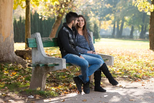 年轻夫妇坐在长椅上 在美丽的秋天天 — 图库照片