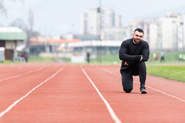 Genç Sporcu Rahatlar ve Stadyumdaki Atletizm Pistinde Koşmaya Hazır
