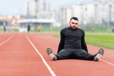 Genç Sporcu Rahatlar ve Stadyumdaki Atletizm Pistinde Koşmaya Hazır
