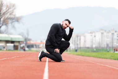 Genç Sporcu Rahatlar ve Stadyumdaki Atletizm Pistinde Koşmaya Hazır