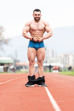 Yakışıklı Sakallı Adam güçlü duruyor ve açık havada poz veriyor.