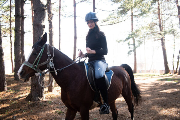 Young Woman Jockey Riding Brown Horse Strolling Across Field