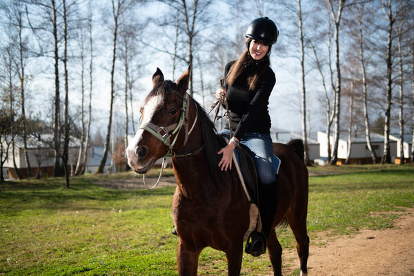 Young Woman Jockey Riding Brown Horse Strolling Across Field