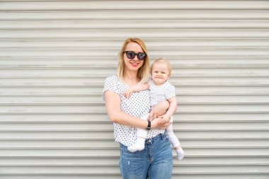 Stil Sevimli Çekici Anne ve Kızının Portresi - Tek Ebeveynli Aile - Gri Garajda İzole edilmiş Kameraya Bakıyor