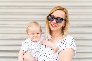 Stil Sevimli Çekici Anne ve Kızının Portresi - Tek Ebeveynli Aile - Gri Garajda İzole edilmiş Kameraya Bakıyor