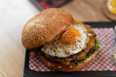 Hamburger, patates kızartması ve soslu Koyu Masa Kokteyli, Meyveli Mojito.