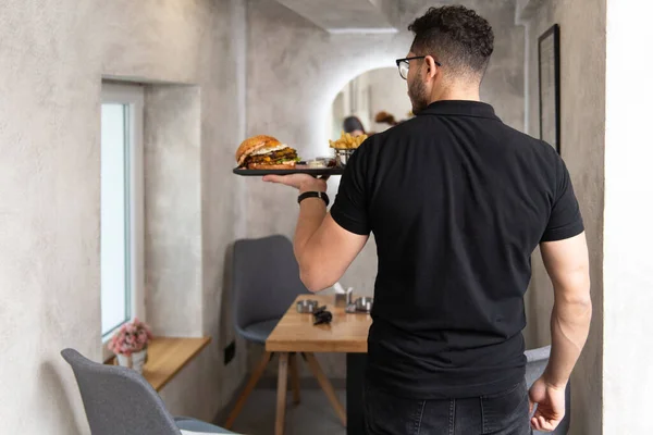 Cameriere Che Tiene Piatto Con Hamburger Patatine Fritte Nel Ristorante — Foto Stock