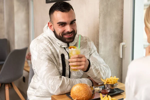 Portrait Young Couple Eating Hamburger Restaurant Drinking Cocktail Passion Fruit — Stock Photo, Image