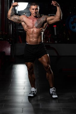 Fiziksel olarak fit bir adamın portresi iyi eğitilmiş vücudunu gösteriyor kaslı atletik vücut geliştirici egzersiz sonrası spor modelliği pozu