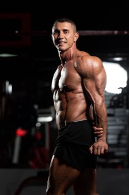 Spor Salonunda Güçlü Duran ve Kaslarını Esneten Adam - Kas Atletik Vücut Geliştirici Spor Sonrası Spor Pozisyonu