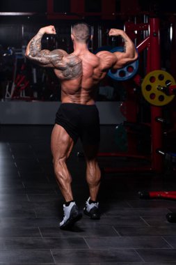 Spor Salonunda Güçlü Duran ve Kaslarını Esneten Adam - Kas Atletik Vücut Geliştirici Spor Sonrası Spor Pozisyonu