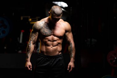 Spor Salonunda Güçlü Duran ve Kaslarını Esneten Adam - Kas Atletik Vücut Geliştirici Spor Sonrası Spor Pozisyonu