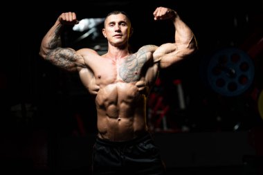 Fiziksel olarak fit bir adamın portresi iyi eğitilmiş vücudunu gösteriyor kaslı atletik vücut geliştirici egzersiz sonrası spor modelliği pozu