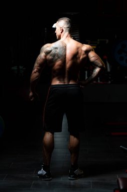 Spor Salonunda Güçlü Duran ve Kaslarını Esneten Adam - Kas Atletik Vücut Geliştirici Spor Sonrası Spor Pozisyonu