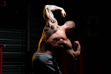 Spor Salonunda Güçlü Duran ve Kaslarını Esneten Adam - Kas Atletik Vücut Geliştirici Spor Sonrası Spor Pozisyonu