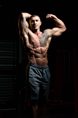 Fiziksel olarak fit bir adamın portresi iyi eğitilmiş vücudunu gösteriyor kaslı atletik vücut geliştirici egzersiz sonrası spor modelliği pozu