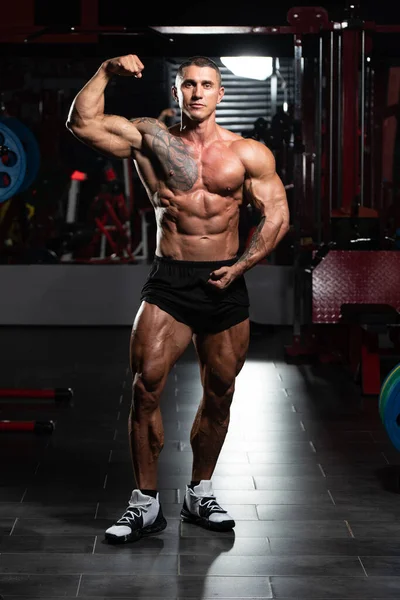 Fiziksel olarak fit bir adamın portresi iyi eğitilmiş vücudunu gösteriyor kaslı atletik vücut geliştirici egzersiz sonrası spor modelliği pozu