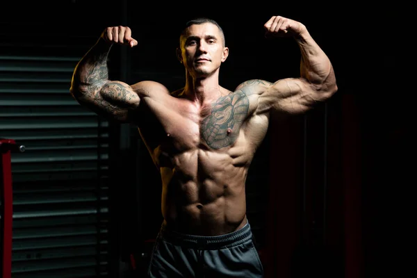 体操と屈曲筋肉に強い立ち男 筋肉運動後にポーズをとる運動体ビルダーフィットネスモデル — ストック写真
