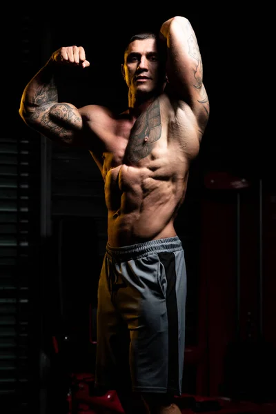 体操と屈曲筋肉に強い立ち男 筋肉運動後にポーズをとる運動体ビルダーフィットネスモデル — ストック写真