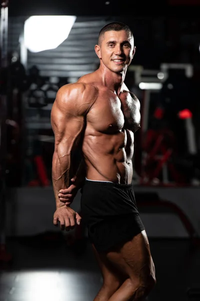 体操と屈曲筋肉に強い立ち男 筋肉運動後にポーズをとる運動体ビルダーフィットネスモデル ロイヤリティフリーのストック写真