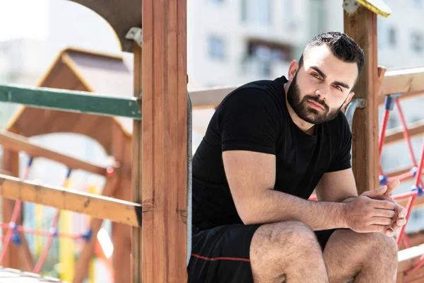 Genç yakışıklı yetişkin adam açık havada doğa poz yerleştirmek