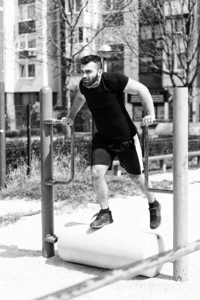 Young Athlete Working Out Triceps In An Outdoor Gym - Doing Street Workout Exercises