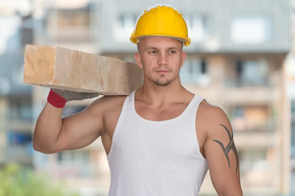 Joven constructor guapo con tablones de madera — Foto de Stock