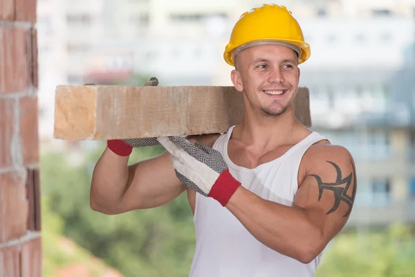 Stilig man transporterar trä plankor — Stockfoto