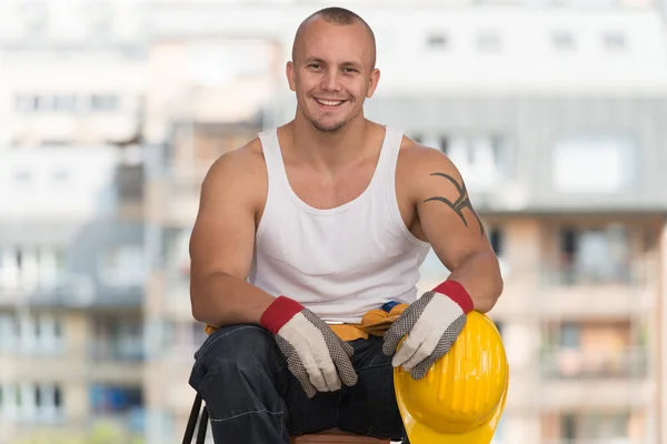 Worker is Resting Sitting On Brick — стоковое фото