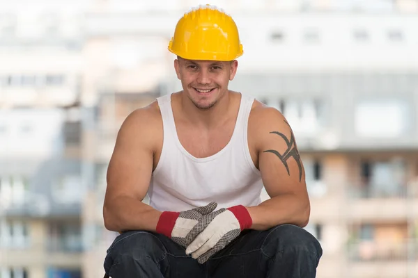 Trabajador está descansando sentado en ladrillo — Foto de Stock