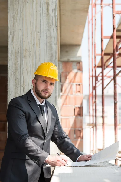 Kaukasische mannelijke bouw manager met blauwdruk — Stockfoto