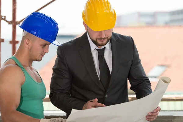 Ingeniero y obrero de la construcción discutiendo un proyecto — Foto de Stock