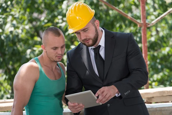 Zakenman en industriële werknemer kijken naar tablet pc — Stockfoto