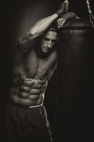 Atrakcyjny mężczyzna z worek bokserski — Zdjęcie stockowe