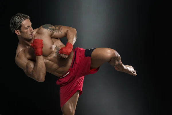 Shirtless boxer muscular com saco de perfuração no ginásio — Fotografia de Stock