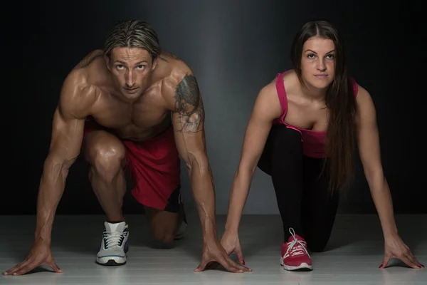 Starkes muskulöses Paar kniet auf dem Boden — Stockfoto