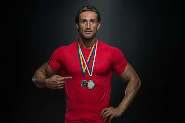 Спортсмен средних лет показал свою медаль за победу — стоковое фото