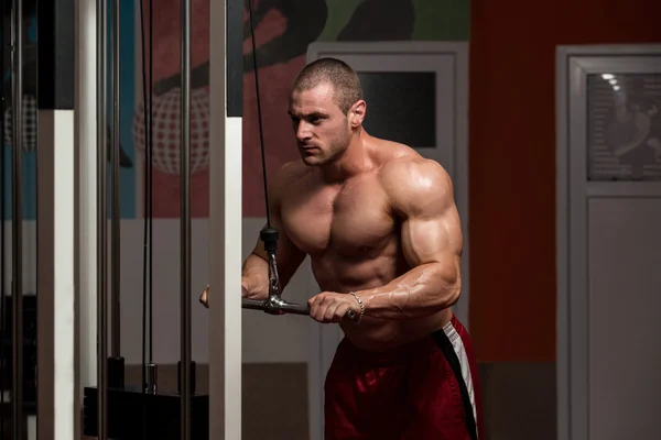 Muskularny mężczyzna robi ciężki ciężar ćwiczenia dla triceps — Zdjęcie stockowe
