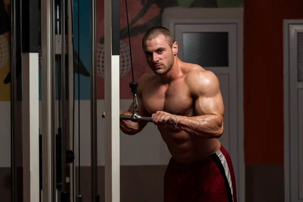 Ung man gör triceps övningar i gymmet — Stockfoto