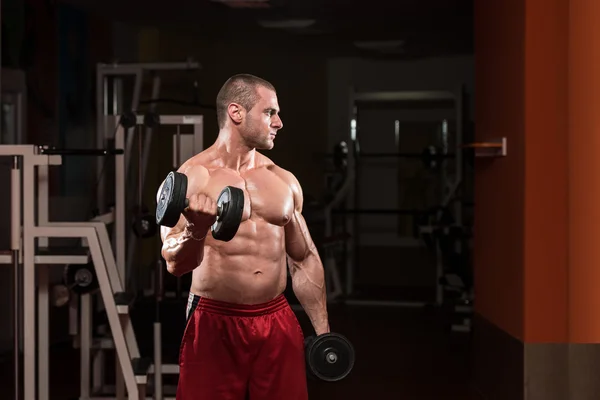 Bodybuilder trainiert Bizeps mit Kurzhanteln — Stockfoto