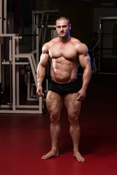 Seriöser Bodybuilder steht im Fitnessstudio — Stockfoto