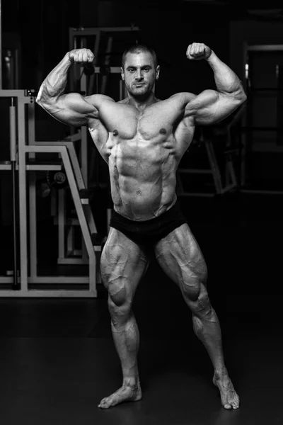 Svalnatý muž je zasáhla zadní dvojitý biceps pozice — Stock fotografie